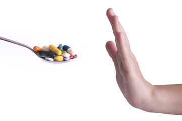 Stop taking antibiotics or drugs concept with spoon full with pills refusal by human hand