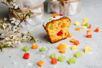 Glazed Easter cake decorated with colorful sprinkles. Complex decor of painted eggs and cherry blossoms. Top view, side view. Space for text.