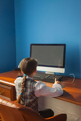 the girl is sitting at the table and working and studying at the computer