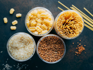 Various pasta and cereal grains in a plastic jars for a long storage.