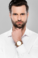 bearded and handsome businessman looking at camera isolated on grey