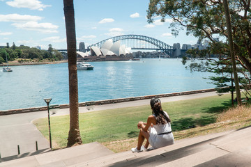 Woman with Sydney Opera House & Harbour Bridge. Tourist looking at attraction, with river water....