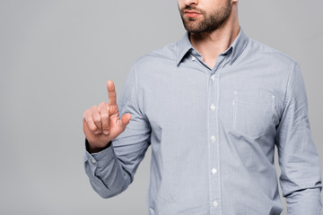 cropped view of bearded businessman pointing with finger isolated on grey