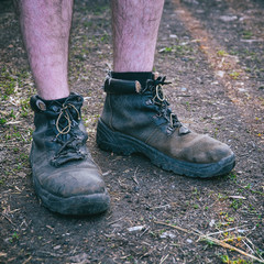 Naked hairy male feet dressed in old shoes