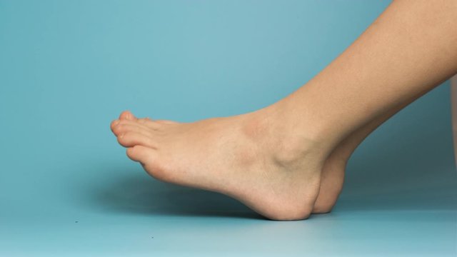 Close up of bare child feet on blue background.