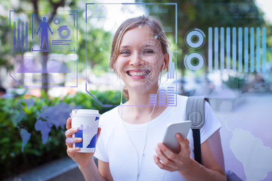 Portrait of happy young woman walking with coffee and earphones. Young Caucasian girl listening to music and smiling at camera through face scan virtual infographics. Technology and leisure concept