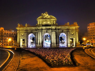 Fototapeta premium Puerta de Alcalá, monumento en el centro de Madrid, iluminado por la noche con luces de Navidad.