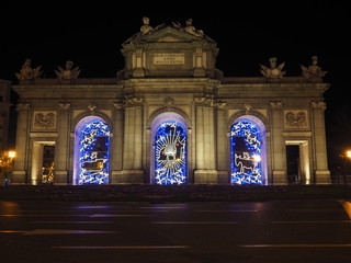 Fototapeta premium Puerta de Alcalá, monumento en el centro de Madrid, iluminado por la noche con luces de Navidad.
