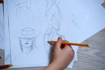 Sketches, sketching on white paper with a simple pencil. Colour pencils
