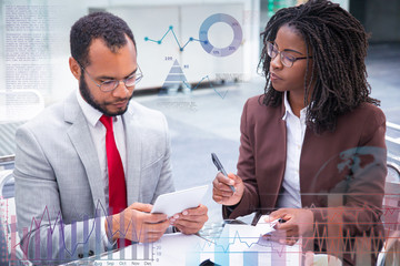 Business colleagues studying reports during coffee break. Business man and woman checking papers with transparent financial charts. Paperwork concept