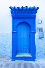 Old blue door on the street of Chefchaouen, the blue city of Morocco. Urban concept.