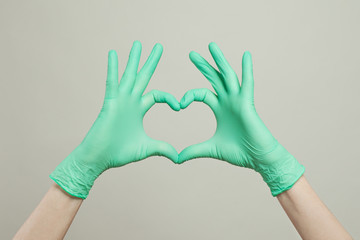 Medical gloves on hands. The heart from the doctor hands in medical gloves on white background