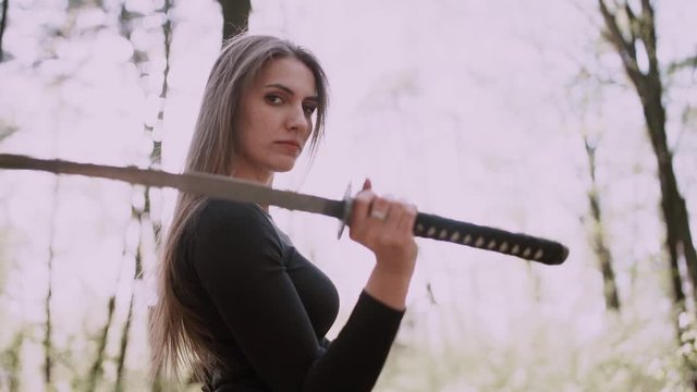 Portrait of a pretty girl with a samurai sword .Girl with a samurai sword fought at sunset.martial arts