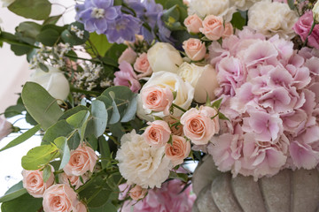 Wedding bouquet of different flowers; pinl, lilac, white roses. Wedding arrengement. Preparation of wedding ceremony in suburbun restaurant