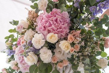 Wedding bouquet of different flowers; pinl, lilac, white roses. Wedding arrengement. Preparation of wedding ceremony in suburbun restaurant