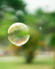 Blurry photo of Soap bubbles floating in the garden park.