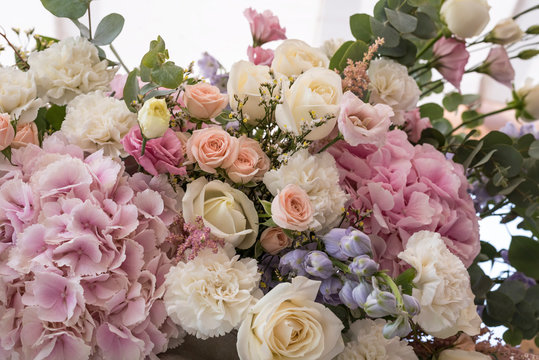 Wedding bouquet of different flowers; pinl, lilac, white roses. Wedding arrengement. Preparation of wedding ceremony in suburbun restaurant