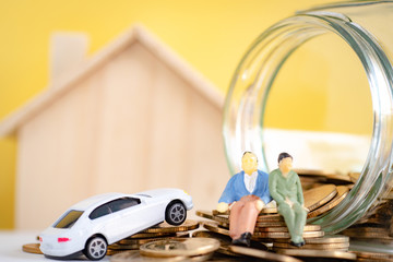 Miniature model, Old couple figure sitting on gold coins . retirement planning concept..