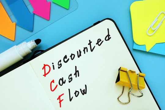 The photo says Discounted Cash Flow DCF. Notepad, pen, marker.