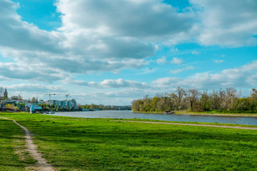 River landscape with green meadows and forests  and blue sky