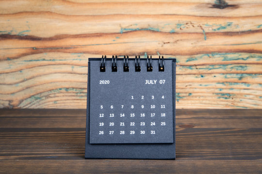 2020 July . Black paper calendar on a wooden table