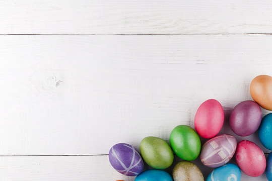 Easter eggs on the right on a white wooden background