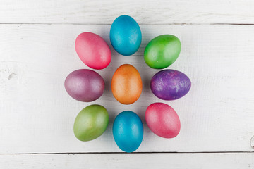 Easter eggs in the shape of the sun on a white wooden background