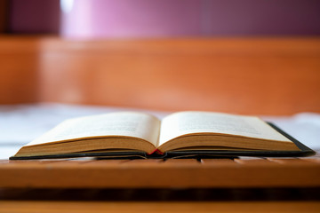 Open book on a white bed.