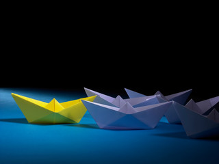 Leadership Concept - Red Paper Boat Followed by purple Paper Boat on Blue Background
