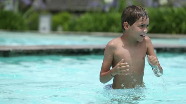 Brothers pretending to be wrestling at the swimming pool. Boys pretend fight rougt and tumble play