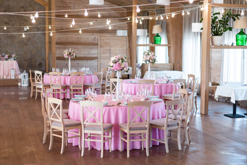 Wedding reception in the restaurant with pink  bouquets and decoration