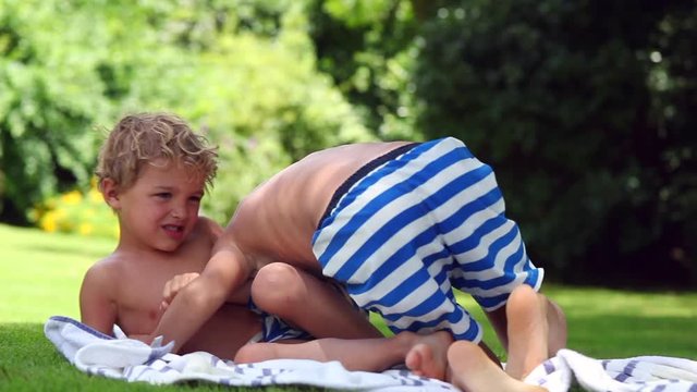 Brothers wrestling each other, siblings fighting one another outside