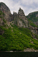 Girls head on rock spire at Western Brook Pond inland fjord at Gros Morne National Park Newfoundland