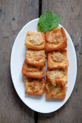 Fried Bread with Minced Pork Spread on a plate, placed on a wooden floor