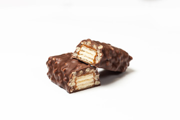 sliced chocolate bar with dark brown chocolate with nuts on a white background.