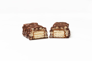 sliced chocolate bar with dark brown chocolate with nuts on a white background.