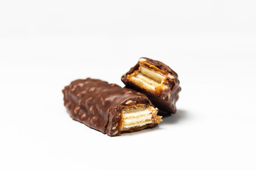 Broken chocolate bar with dark brown chocolate with nuts on a white background.