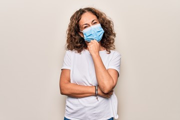 Middle age woman wearing coronavirus protection mask for covid-19 epidemic virus smiling looking...