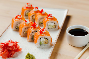 Japanese sushi roll set on delivery in quarantine. Red dragon. Rice, nori, tempura shrimp, tabasco sauce, cucumber, fresh salmon, salmon caviar.