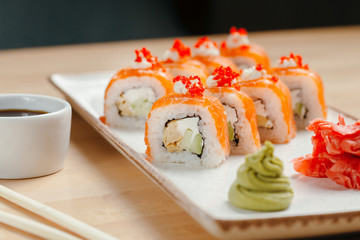 Japanese sushi roll set on delivery in quarantine. Red dragon. Rice, nori, tempura shrimp, tabasco sauce, cucumber, fresh salmon, salmon caviar.