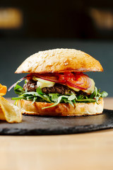 Beef burger with tomatos and potato chips. Junk food. Fastfood. Bodypositive. Food on quarantine from delivery. Photo for menu.