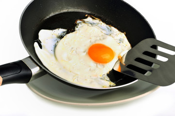 Un œuf au plat cuit à la poêle sur fond blanc