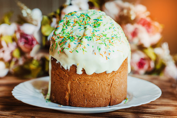 Glazed easter cake decorated with colored powder on wooden background. Happy Easter Holidays.