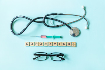 Text phrase Coronavirus syringe eyeglasses and stethoscope on blue pastel background. Novel coronavirus 2019-nCoV MERS-Cov covid-19 middle East respiratory syndrome coronavirus virus vaccine concept.