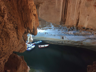 Big rude cave with lake.  Boats on the lake in the cave top view.