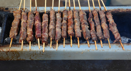 lamb skewers while cooking called ARROSTICINI in Italian