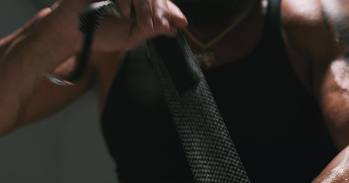 Low angle close up of fighter's hand as he wraps it.