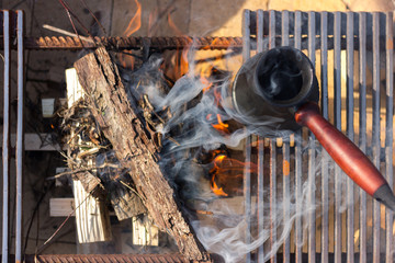 A method of making coffee on fire. Beautiful flames and smoke around the coffee. Space for text. Lifestyle