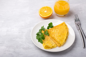 Keto breakfast high-fat low-carb, pancakes without flour and nuts, freshly squeezed orange juice and orange on a light gray background