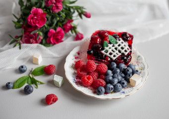 Delicious beautiful dessert with fresh berries and a bouquet of flowers in rows, sweet still life. Selective focus.